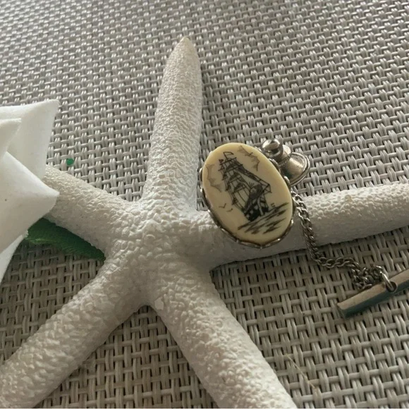 Vintage scrimshaw tie tac with a tall sailing ship.